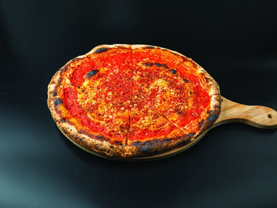 Marinara pizza on a wooden paddle